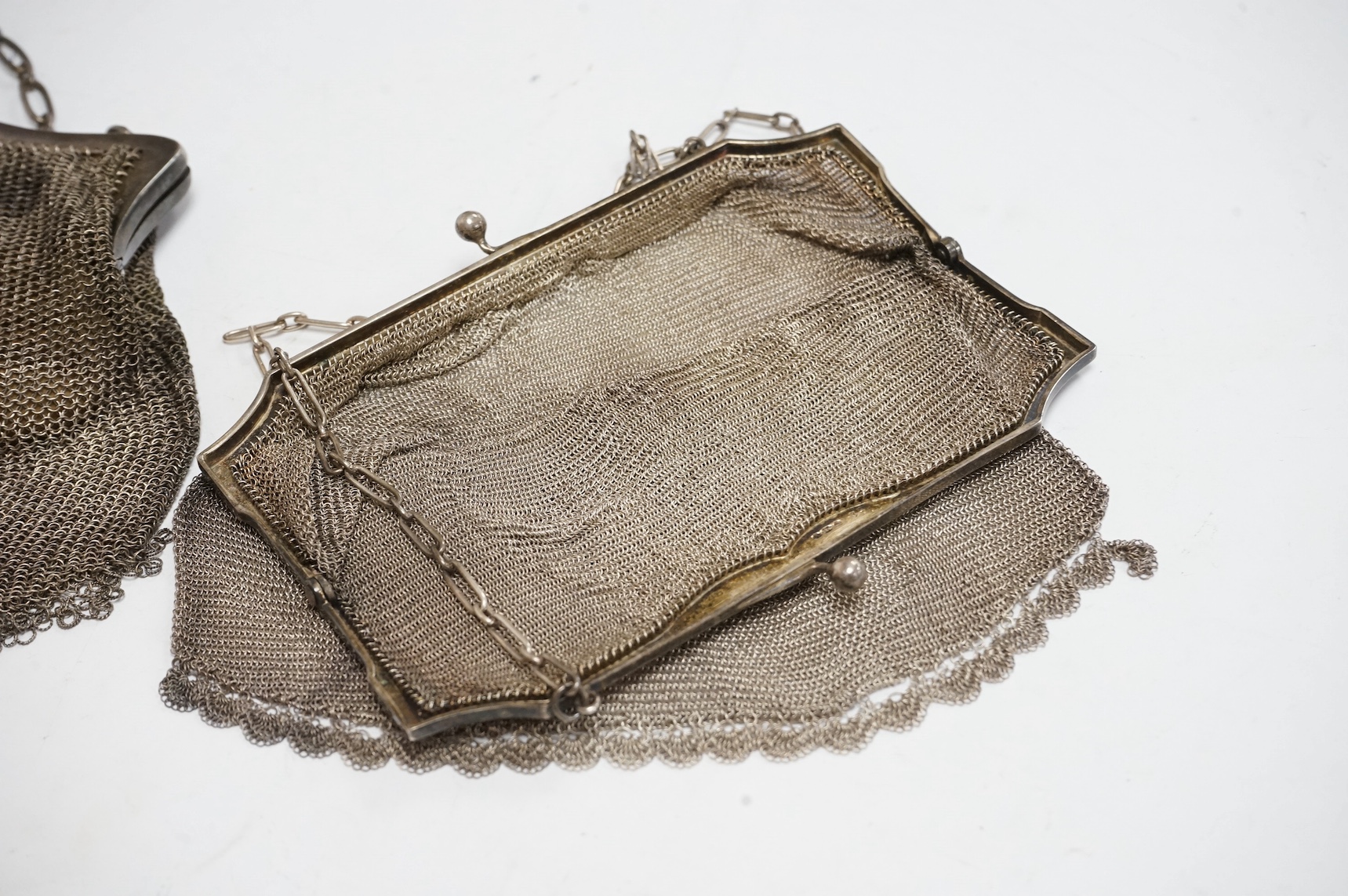 A George V silver mesh evening bag, import marks for Jacques Brown & Co, Chester, 1915, width 15.4cm, together with one other silver mesh evening bag. Condition - fair